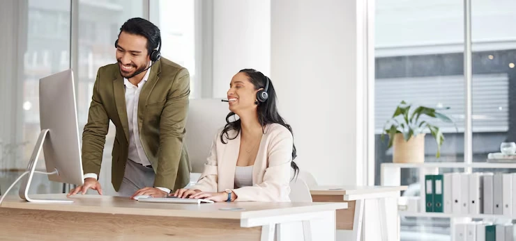 Two Professional Telemarketing Team Members With Headsets Setting Appointments On A Computer In A Calgary Office