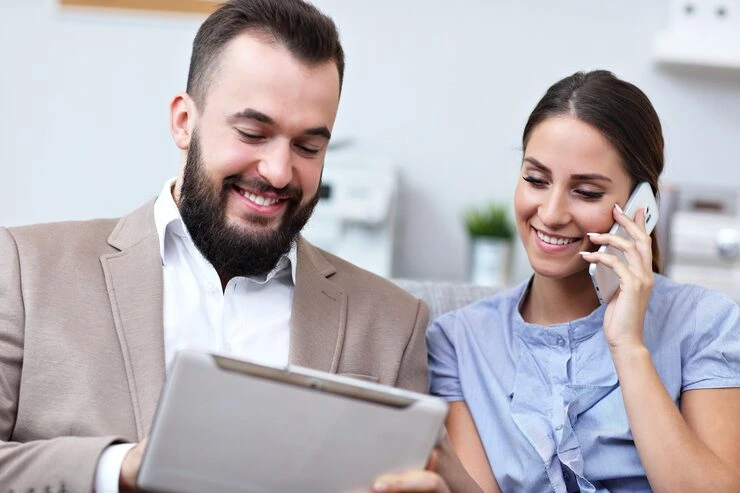Two Business Professionals Smiling While Setting Appointments Through Cold Calling In A Vancouver Office