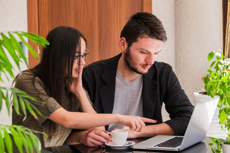 Two Telemarketing Professionals Reviewing Follow Up And Lead Nurturing Strategy On A Laptop In A Calgary Office