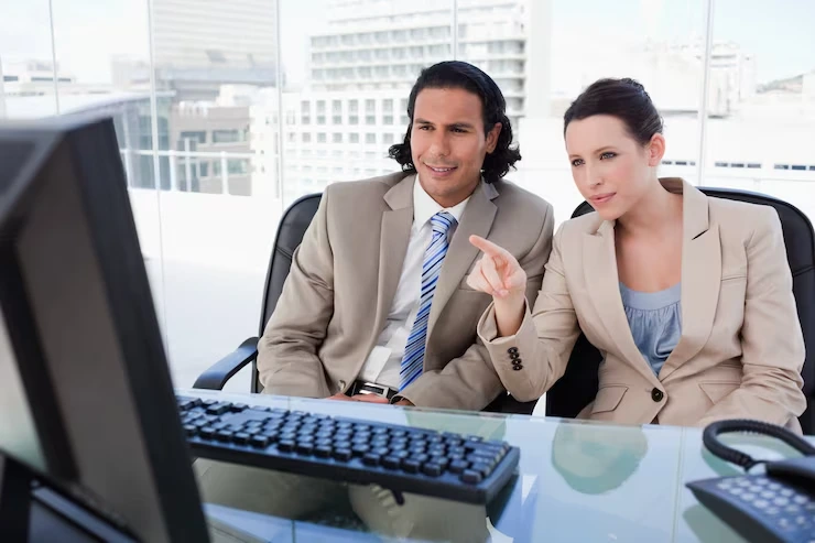 Two Professional Telemarketing Team Members Reviewing New Sales Opportunities On A Computer In A Calgary Office