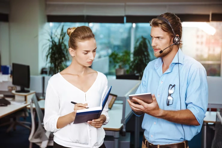 A Professional Telemarketing Team Member With A Headset Discussing Business Expansion Strategy With A Colleague In A Calgary Office